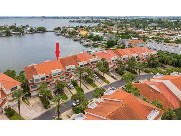 Aerial view of waterfront property with private boat docks at 4633 Mirabella Ct, St Pete Beach, FL 33706