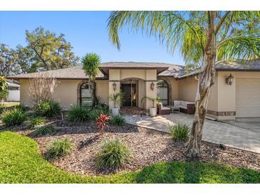 Charming single-story home featuring a manicured front yard and inviting entryway with mature trees and landscaping at 1105 Deer Run Pl, Valrico, FL 33594