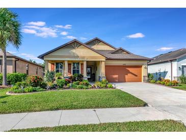 One-story house with orange garage door and landscaped yard at 6342 Kenava Loop, Palmetto, FL 34221