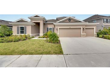 Two-story home with landscaped yard and two-car garage at 5608 Madrigal Way, Apollo Beach, FL 33572