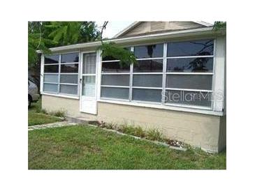 Cozy home with a sunroom and well-maintained lawn at 18005 1St E St, Redington Shores, FL 33708