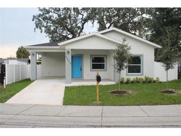 Single-story home with a bright blue front door and landscaped yard at 4004 E Osborne Ave, Tampa, FL 33610