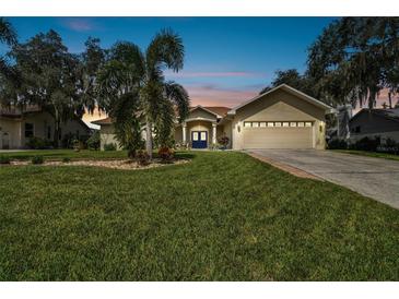 Tan two-story house with a two-car garage and well-manicured lawn at 1905 Masters Way, Plant City, FL 33566