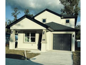 Two-story house with a modern design, two-car garage, and a front porch at 4405 N 24Th St, Tampa, FL 33610