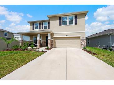 Beautiful two-story house with stone accents and a two-car garage at 8861 Forge Breeze Loop, Wesley Chapel, FL 33545