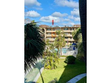 View of community pool, shuffleboard courts, and lush landscaping at 2525 W Bay Dr # B32, Largo, FL 33770