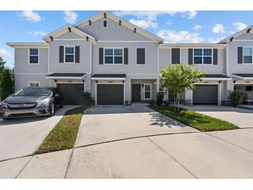 Three-unit townhome building with parking and landscaping at 10985 Brightleaf Ct, Riverview, FL 33569