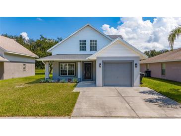 Newly constructed home with gray garage and well-manicured lawn at 10209 Summerview Cir, Riverview, FL 33578