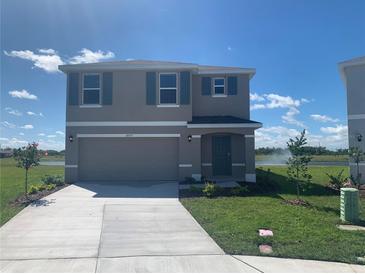 Charming two-story home featuring a well-manicured lawn, attached garage, and classic architectural details at 10257 Kalamazoo Pl, Parrish, FL 34219