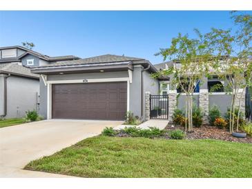 Modern house exterior featuring a two-car garage and landscaping at 281 Villa Corte Dr, Lutz, FL 33549