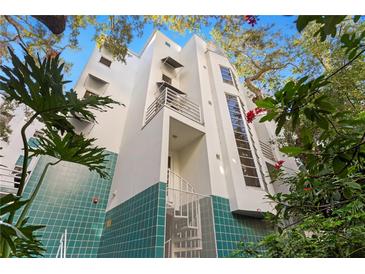 Modern building with teal tile accents and lush landscaping at 4950 Bayshore Blvd # 13C, Tampa, FL 33611