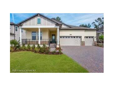 Charming home featuring a manicured lawn, covered porch, and a three-car garage at 4638 Southern Valley Loop, Brooksville, FL 34601