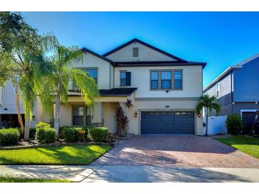 Two-story house with a gray garage door and attractive landscaping at 19462 Paddock View Dr, Tampa, FL 33647