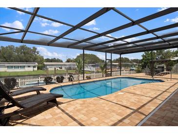 Relaxing pool area with covered patio, lounge chairs, and canal views at 245 78Th N Ave, St Petersburg, FL 33702