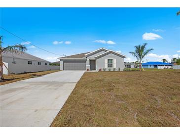 Single-story home with gray siding and attached garage at 1345 Loveland Blvd, Port Charlotte, FL 33980