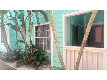 Charming teal building exterior with tropical landscaping and a private entrance at 3002 W Cleveland St # E1, Tampa, FL 33609