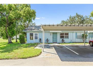 Light blue house with carport and well-manicured lawn at 2222 Greenhaven Dr, Sun City Center, FL 33573