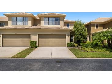 Tan two-car garage townhome with landscaping at 2539 Silverback Ct, Palm Harbor, FL 34684