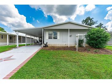 Mobile home with carport, star-shaped driveway, and landscaping at 36750 Kimela Ave, Zephyrhills, FL 33542