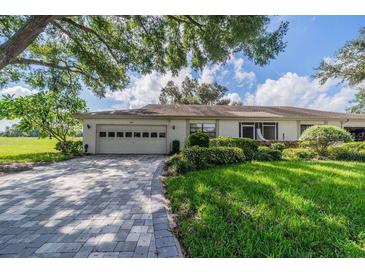 Single-story home with attached garage and landscaped yard at 2535 Lancaster Dr # 2535, Sun City Center, FL 33573