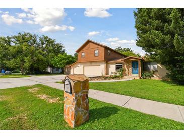 Two-story house with a large yard, attached garage, and stone accents at 10213 Newport Cir, Tampa, FL 33612
