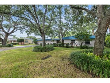 Ranch-style home with mature trees and landscaping at 4915 W Melrose N Ave, Tampa, FL 33629