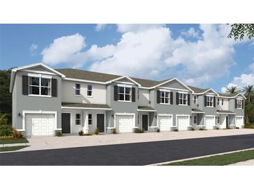 Exterior of a modern townhouse with gray siding and white garage doors at 17477 Haysack Ter, Lakewood Ranch, FL 34211