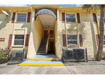 Building exterior with stairs, awning, and red shutters at 7585 Abonado Rd, Tampa, FL 33615