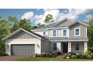 Two story home with gray siding and a three-car garage at 11209 Manor House Ln, Odessa, FL 33556