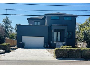 Contemporary new construction home featuring a two-car garage and dark exterior paint at 4716 W Euclid Ave, Tampa, FL 33629