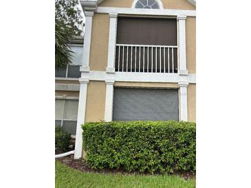 Exterior view of building showing a tan building with white accents, balcony, and landscaping at 9481 Highland Oak Dr # 505, Tampa, FL 33647