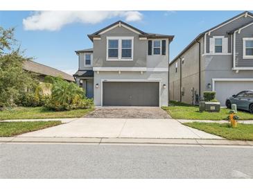 Two-story house with gray siding, two-car garage, and landscaped front yard at 2848 Gridiron Isle, New Port Richey, FL 34655
