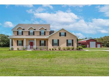 Two-story house with a red door and barn at 8703 Alafia Hills Dr, Plant City, FL 33567