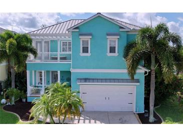 Stunning teal two-story home with a white garage door at 6564 Simone Shores Cir, Apollo Beach, FL 33572