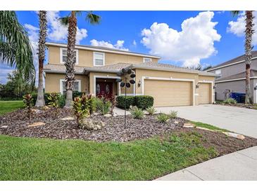 Two-story house with three car garage and landscaped yard at 5806 Candytuft Place, Land O Lakes, FL 34639