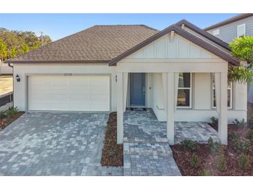 Charming single-story home showcasing a brick driveway, a one car garage and a welcoming covered entry porch at 13728 Sunlight Meadow Dr, Riverview, FL 33578