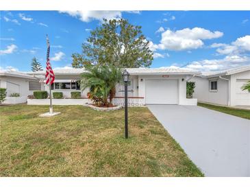 White Ranch house with American flag and palm tree at 9820 44Th N Way, Pinellas Park, FL 33782