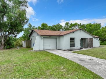 Single-story home with attached garage and well-maintained lawn at 6485 India Dr, Spring Hill, FL 34608