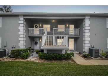 Two-story condo building with a balcony and landscaping at 12133 Spartan Way # 204, Hudson, FL 34667