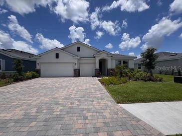 Beautiful single-story home boasting a manicured lawn, paver driveway, and a two-car garage at 4311 Pullet Ct, Lakewood Ranch, FL 34211