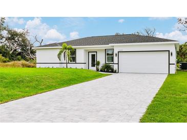 Modern house exterior with a gray roof and paved driveway at 16451 Strauss Ave, Port Charlotte, FL 33954