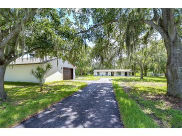 Home with long driveway, detached garage, and mature trees at 8921 Honeywell Rd, Gibsonton, FL 33534