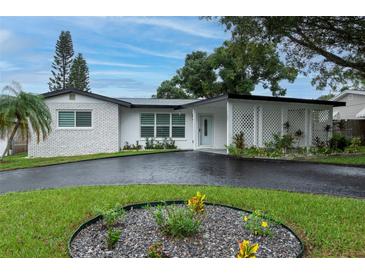 Charming one-story home featuring a brick facade, covered porch, and landscaped front yard at 11452 81St Pl, Seminole, FL 33772