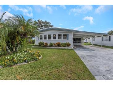 Single-wide manufactured home with carport and landscaped yard at 198 Philadelphia Blvd # 11, Palm Harbor, FL 34684