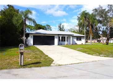 Newly renovated home with a black garage door at 9085 Dorsey St, Spring Hill, FL 34608