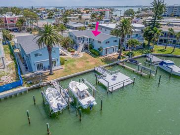 Waterfront home featuring two docks, boat lifts, lush landscaping, and spacious backyard at 241 Skiff Pt # 4, Clearwater Beach, FL 33767