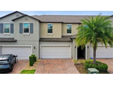 Two-story townhouse with attached garage and landscaping at 10012 Corso Milano Dr, Tampa, FL 33625