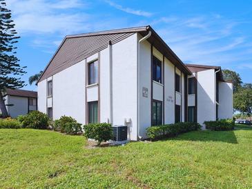 Exterior view of a light-colored building with landscaping at 2688 Pine Ridge N Way # A2, Palm Harbor, FL 34684