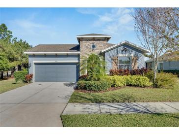 One-story home with gray siding, stone accents, and landscaped yard at 6419 Blue Sail Ln, Apollo Beach, FL 33572