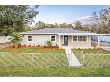 Newly renovated home with gray exterior, landscaping, and a covered porch at 10112 Midway St, Gibsonton, FL 33534